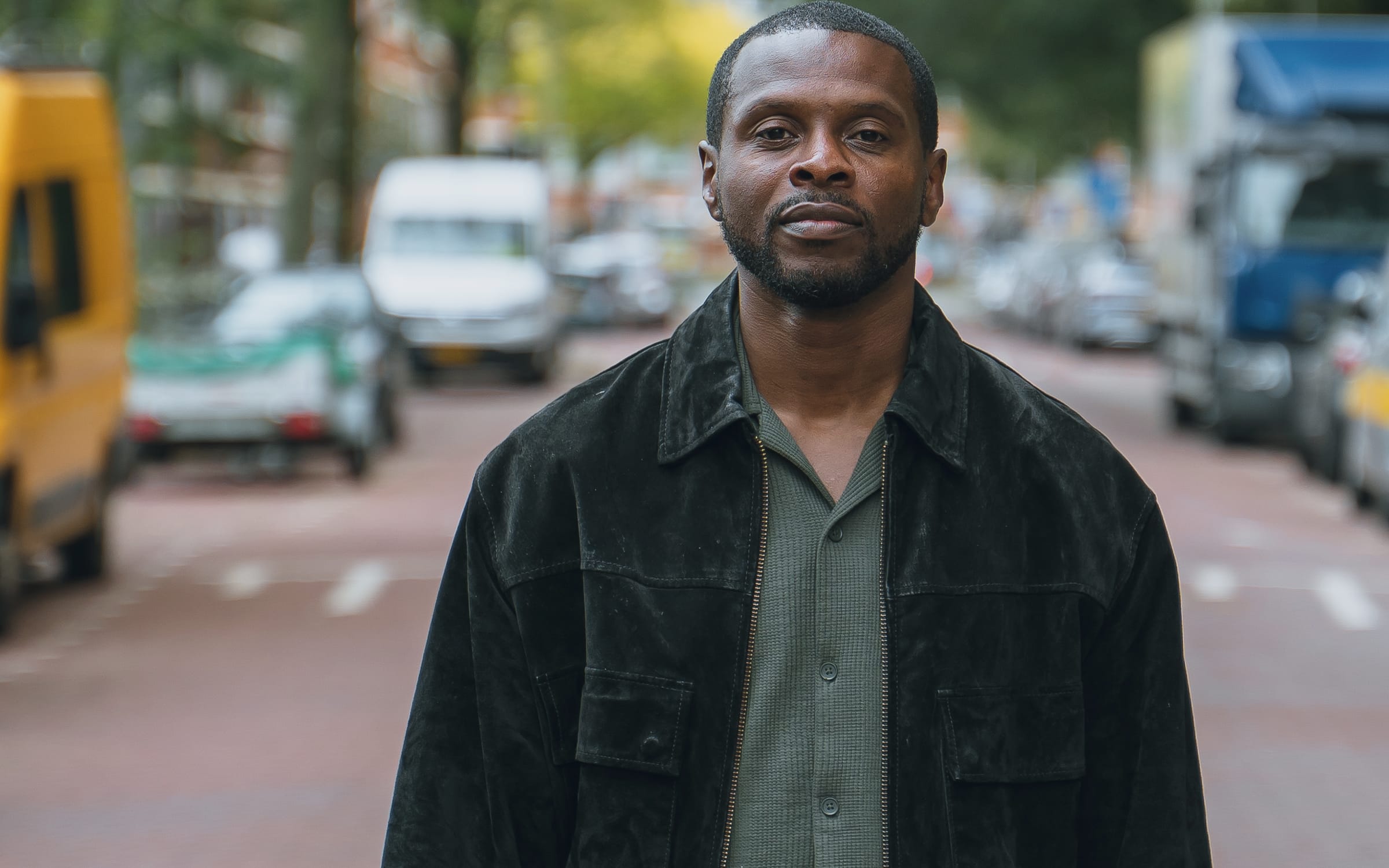 Godwin staat op straat in Den Haag en kijkt recht in de camera.